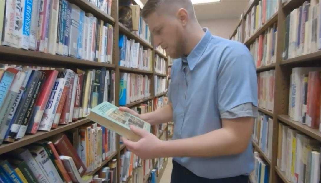Correctional Education student looking at materials in library